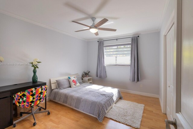 bedroom featuring crown molding, a closet, ceiling fan, and light wood-type flooring