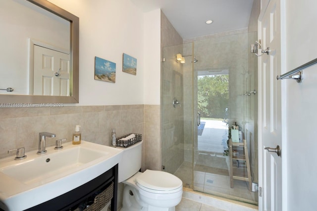 bathroom with vanity, toilet, an enclosed shower, and tile walls