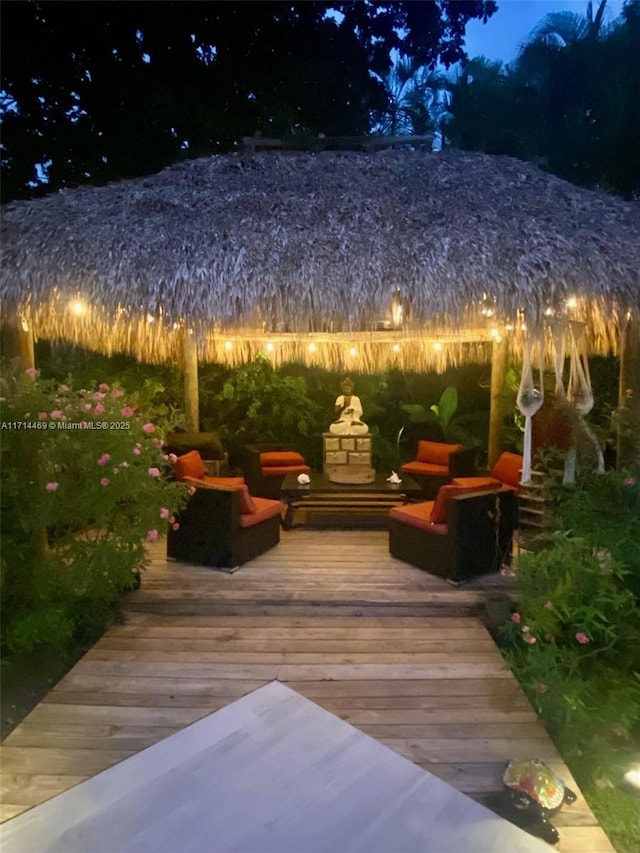 wooden terrace with a gazebo and an outdoor living space with a fireplace