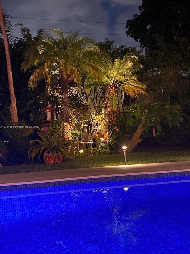 view of pool at twilight