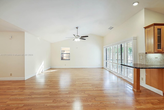 unfurnished living room with ceiling fan, lofted ceiling, and light wood-type flooring