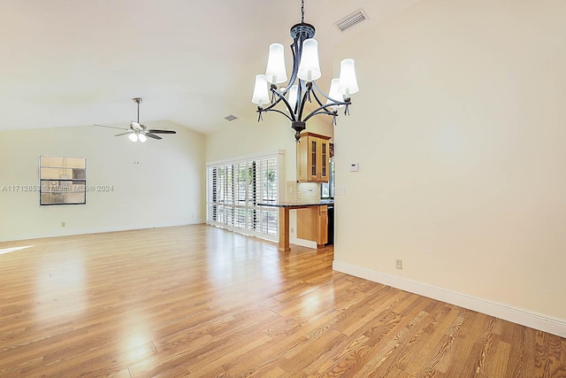 unfurnished living room with ceiling fan with notable chandelier, lofted ceiling, and light wood-type flooring