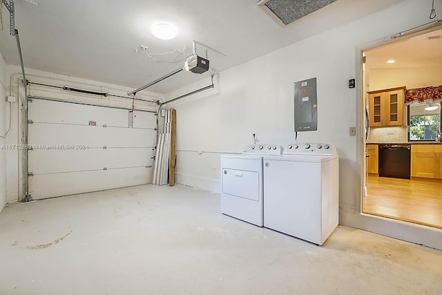 garage with electric panel, washer and dryer, and a garage door opener