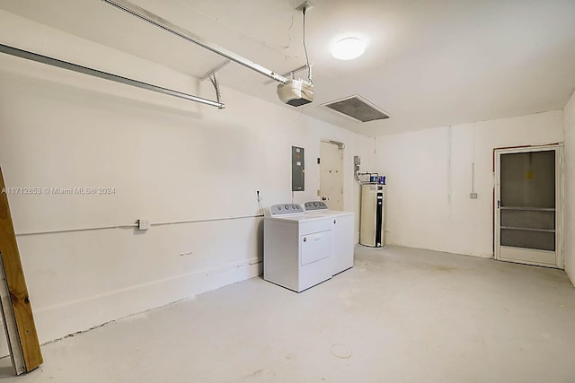 garage featuring independent washer and dryer, electric panel, and a garage door opener