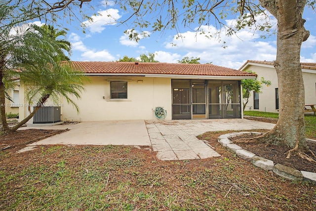 back of house with central air condition unit, a sunroom, and a patio