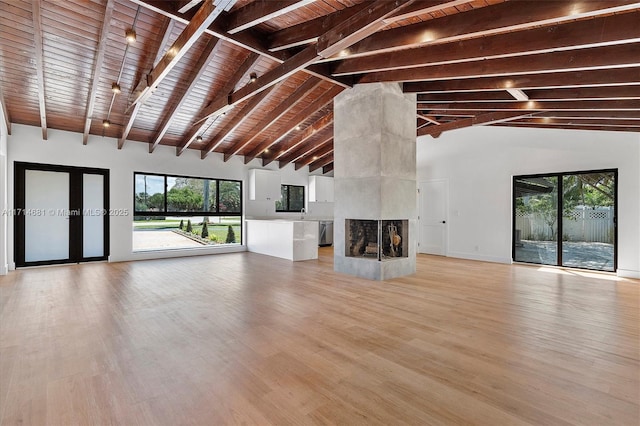 unfurnished living room with a multi sided fireplace, high vaulted ceiling, light wood-type flooring, wood ceiling, and beam ceiling