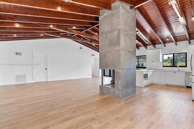 unfurnished living room with beamed ceiling, high vaulted ceiling, light hardwood / wood-style flooring, and wooden ceiling