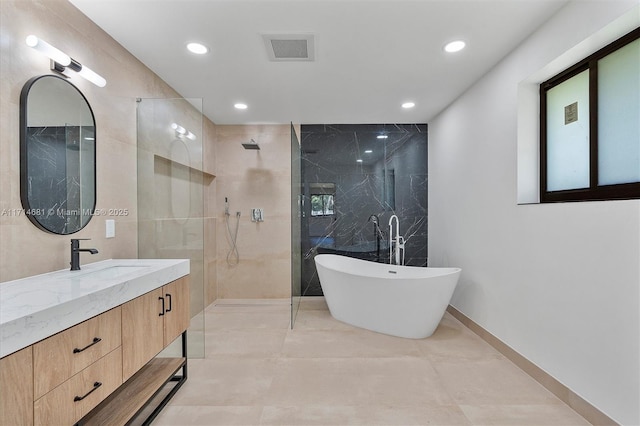 bathroom featuring vanity, plus walk in shower, and tile walls