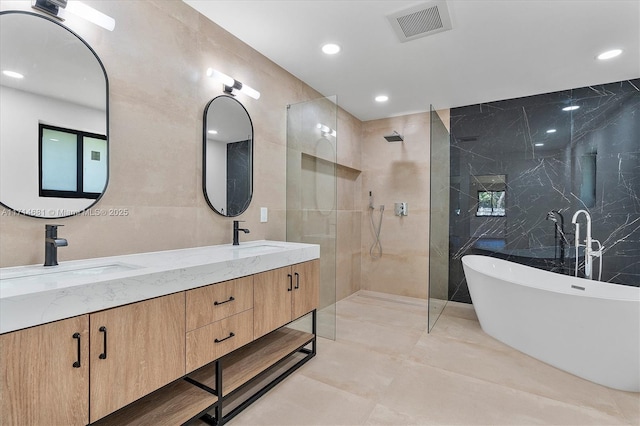 bathroom featuring vanity, separate shower and tub, and tile walls