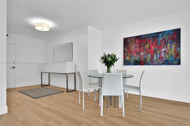 dining space with wood-type flooring