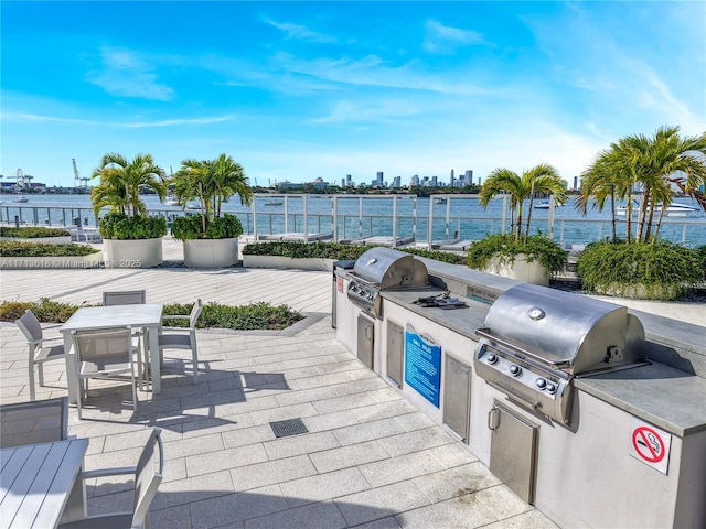 view of patio / terrace with exterior kitchen, grilling area, and a water view