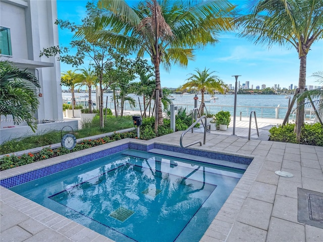 view of swimming pool featuring a patio and a water view