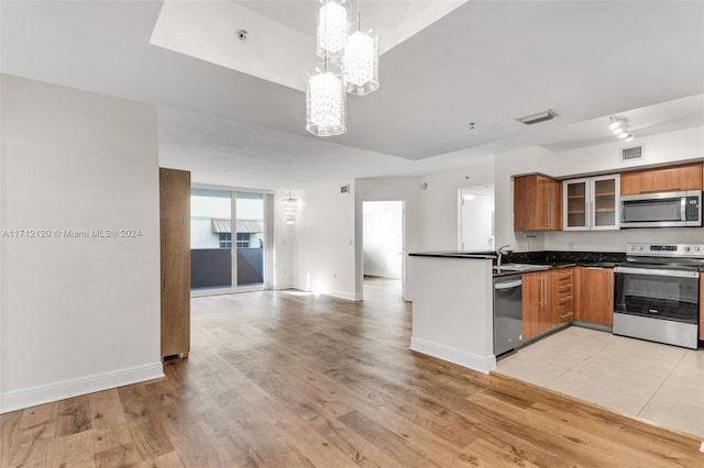 kitchen with light hardwood / wood-style flooring, a chandelier, decorative light fixtures, and appliances with stainless steel finishes