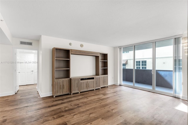 unfurnished living room featuring dark hardwood / wood-style flooring and a wall of windows