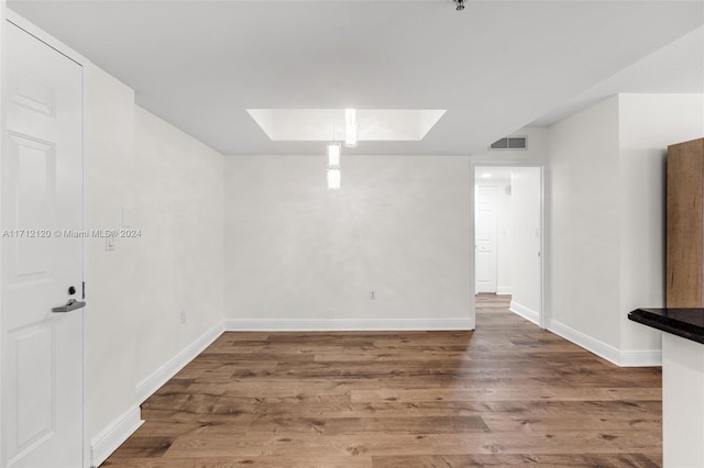 empty room with a skylight and hardwood / wood-style flooring