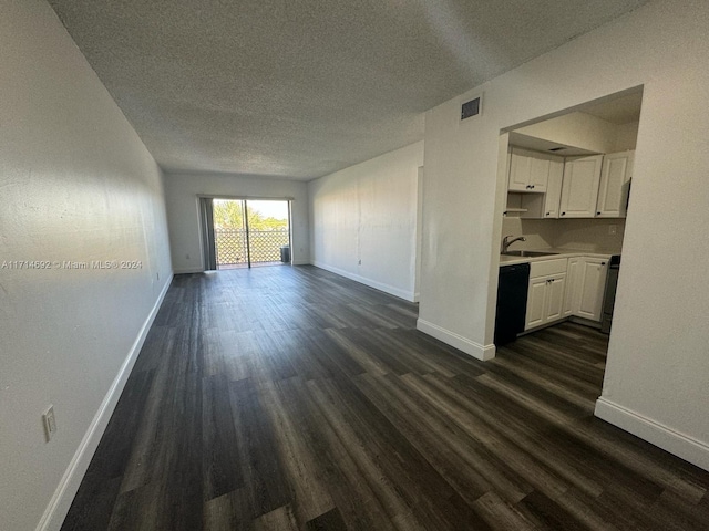 unfurnished living room featuring a textured ceiling, sink, and dark wood-type flooring