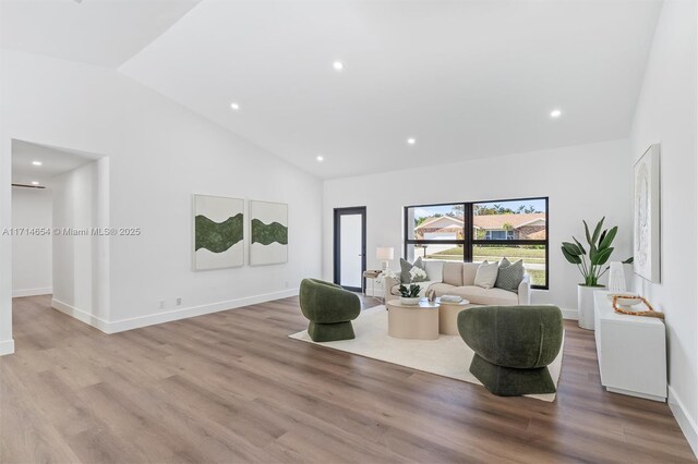 living room featuring light wood-type flooring and high vaulted ceiling