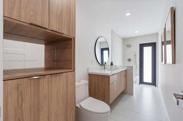 bathroom with vanity, toilet, and a bathing tub