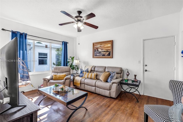 living room featuring a textured ceiling, dark hardwood / wood-style floors, and ceiling fan