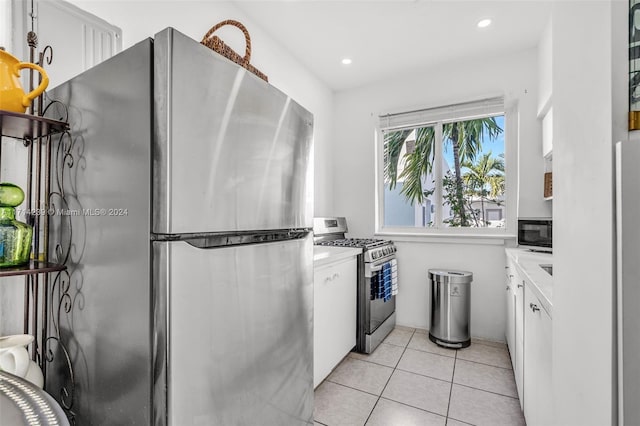 kitchen featuring appliances with stainless steel finishes, white cabinetry, and light tile patterned flooring