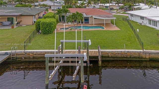 dock area with a patio area, a yard, and a water view