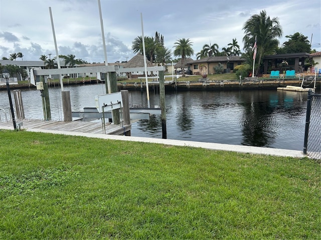 dock area featuring a lawn and a water view