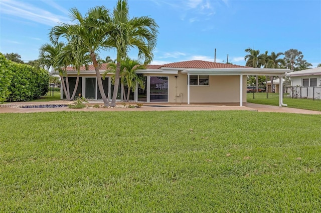 rear view of house with a carport and a yard