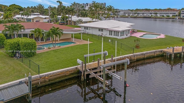 dock area with a lawn, a water view, and a fenced in pool