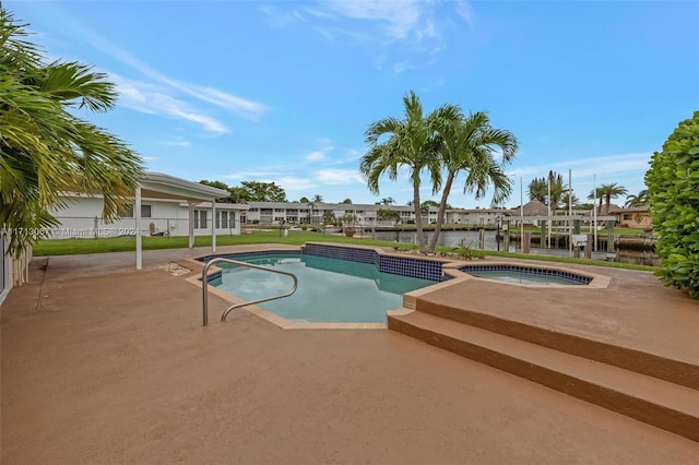 view of pool featuring a patio area, a water view, and an in ground hot tub