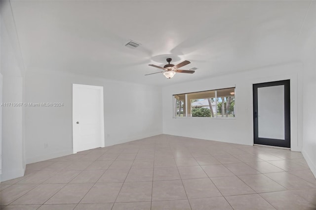 tiled spare room featuring ceiling fan