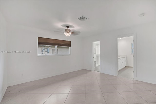 tiled empty room featuring ceiling fan