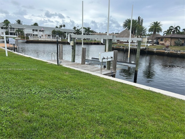 dock area featuring a water view and a lawn