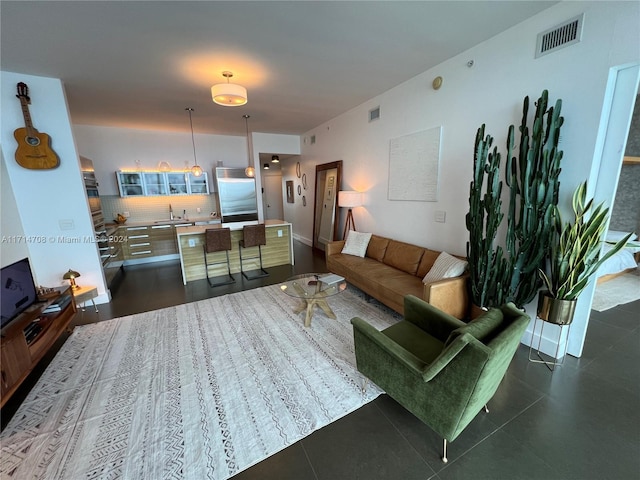 living room featuring dark tile patterned floors and sink