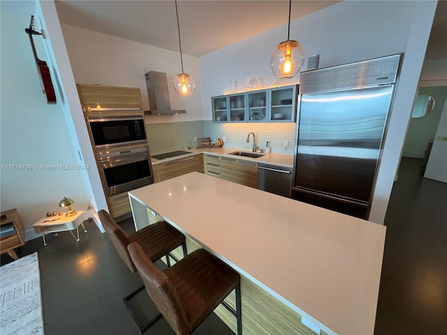 kitchen featuring sink, hanging light fixtures, wall chimney exhaust hood, and black appliances