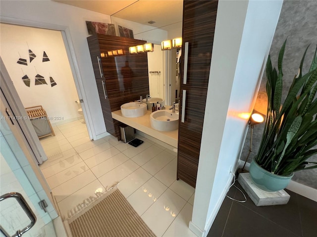 bathroom with tile patterned flooring, vanity, and walk in shower