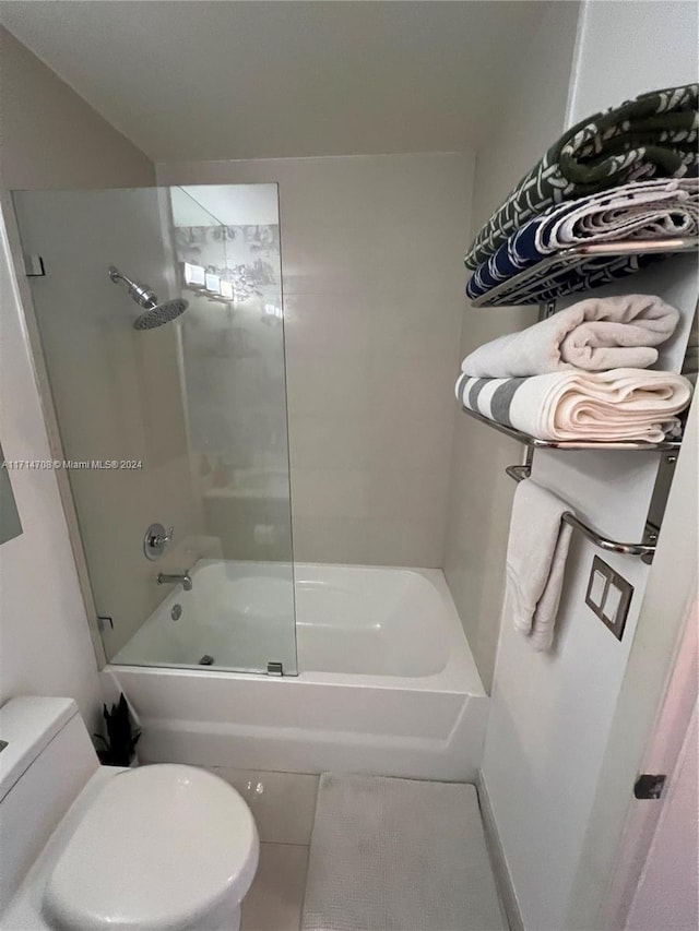 bathroom featuring tile patterned flooring, toilet, and washtub / shower combination