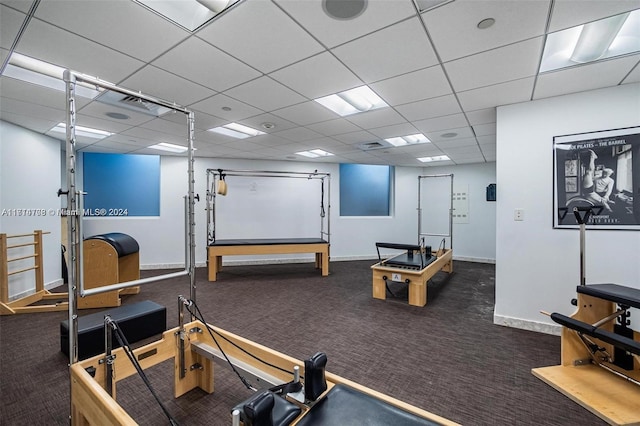 gym with dark colored carpet and a drop ceiling