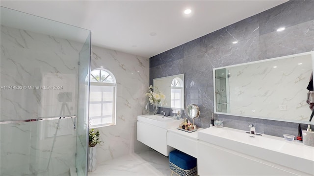 bathroom featuring a shower with door, vanity, and tile walls