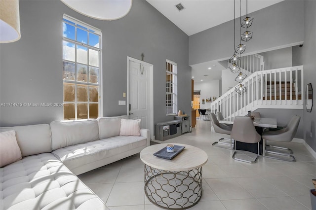 living room featuring a towering ceiling and light tile patterned floors