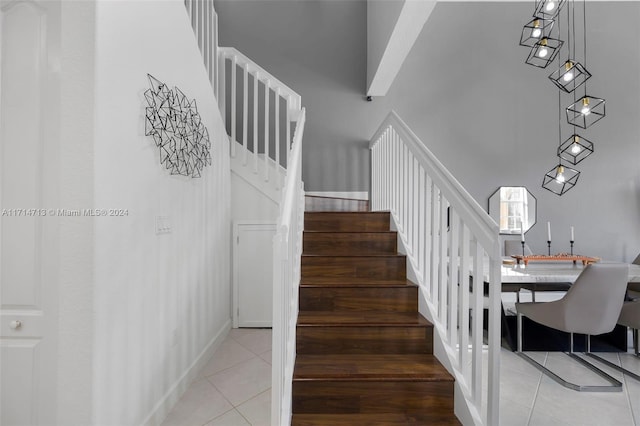 staircase featuring tile patterned flooring and a towering ceiling