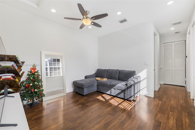 living room with dark hardwood / wood-style flooring and ceiling fan