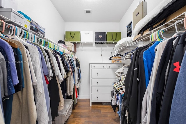 walk in closet with dark wood-type flooring