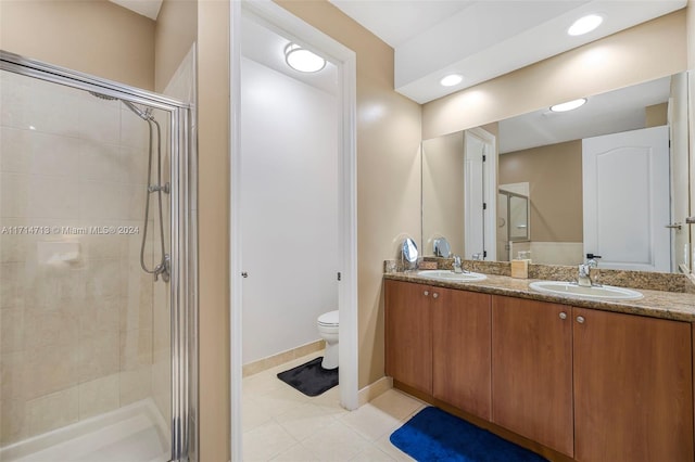 bathroom with tile patterned floors, vanity, toilet, and an enclosed shower