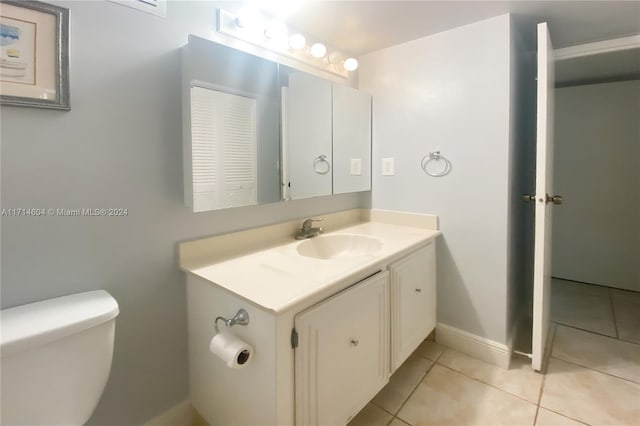 bathroom featuring tile patterned flooring, vanity, and toilet