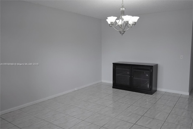 spare room with light tile patterned floors and a notable chandelier