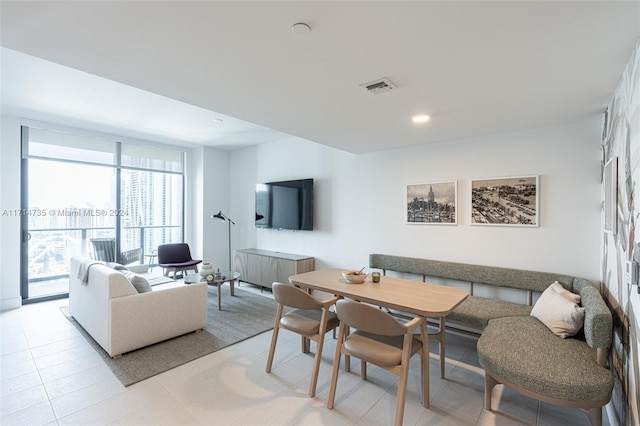 dining space featuring expansive windows and light tile patterned flooring