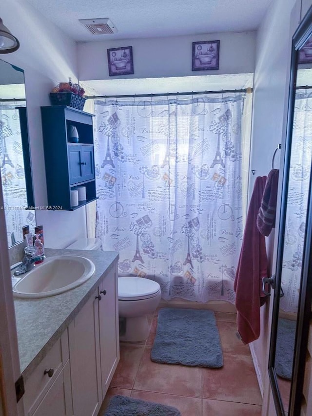 full bathroom with tile patterned floors, a textured ceiling, vanity, shower / tub combo with curtain, and toilet