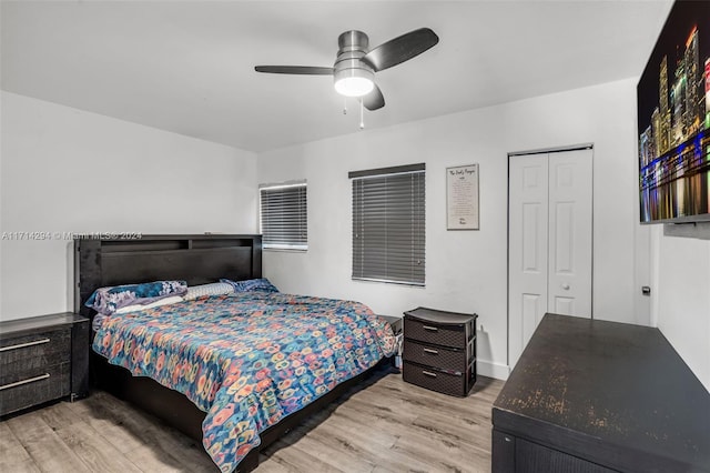 bedroom with a closet, light hardwood / wood-style flooring, and ceiling fan