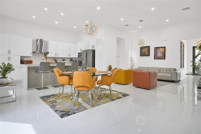 tiled dining area featuring a high ceiling and a notable chandelier