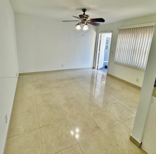 spare room with ceiling fan and light tile patterned floors